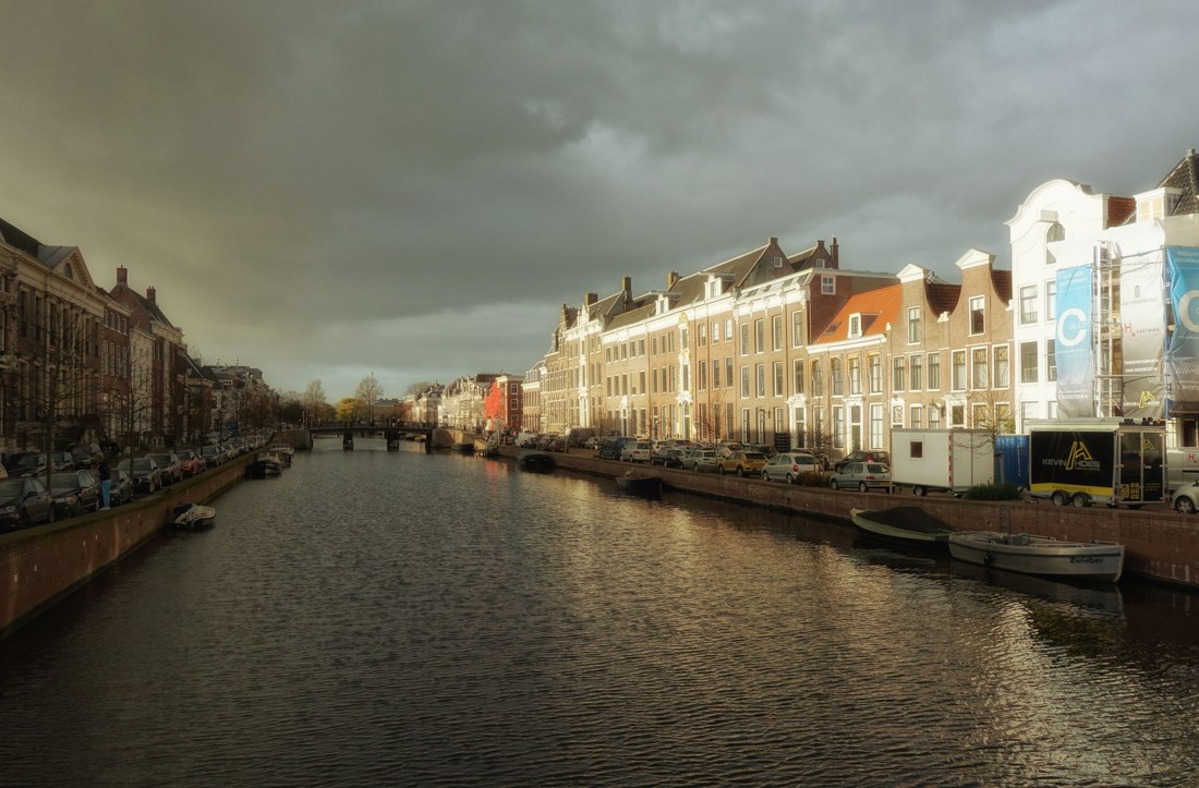 Een Haarlemse gracht met historische gebouwen en bewolkte lucht